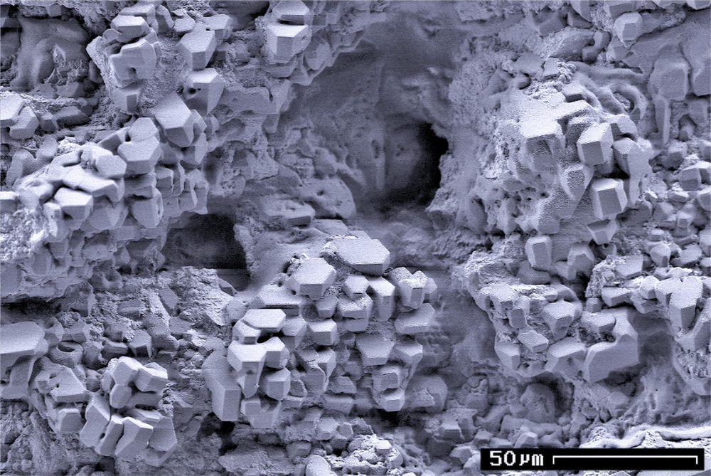 Scanning electron microscope image of gas hydrate crystals in a sediment sample is shown. The scale is 50 micrometers (µm) or about 0.002 inches. (Source: USGS)