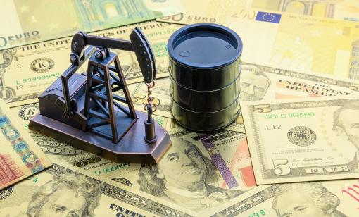 A mini oil rig and barrel on top of money