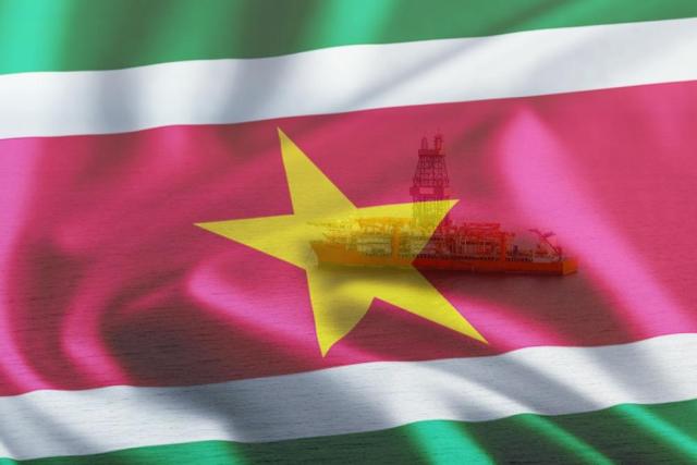 Pictured Suriname flag and drillship Noble Sam Croft, which was used to drill the Maka Central-1 offshore Suriname on Block 58. (Source: Noble Corp. Plc/Shutterstock.com)
